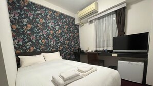 A hotel room with a bed, a desk, a television, and an air conditioning unit. - FORBELL STAY YURIGAOKA (Kawasaki)