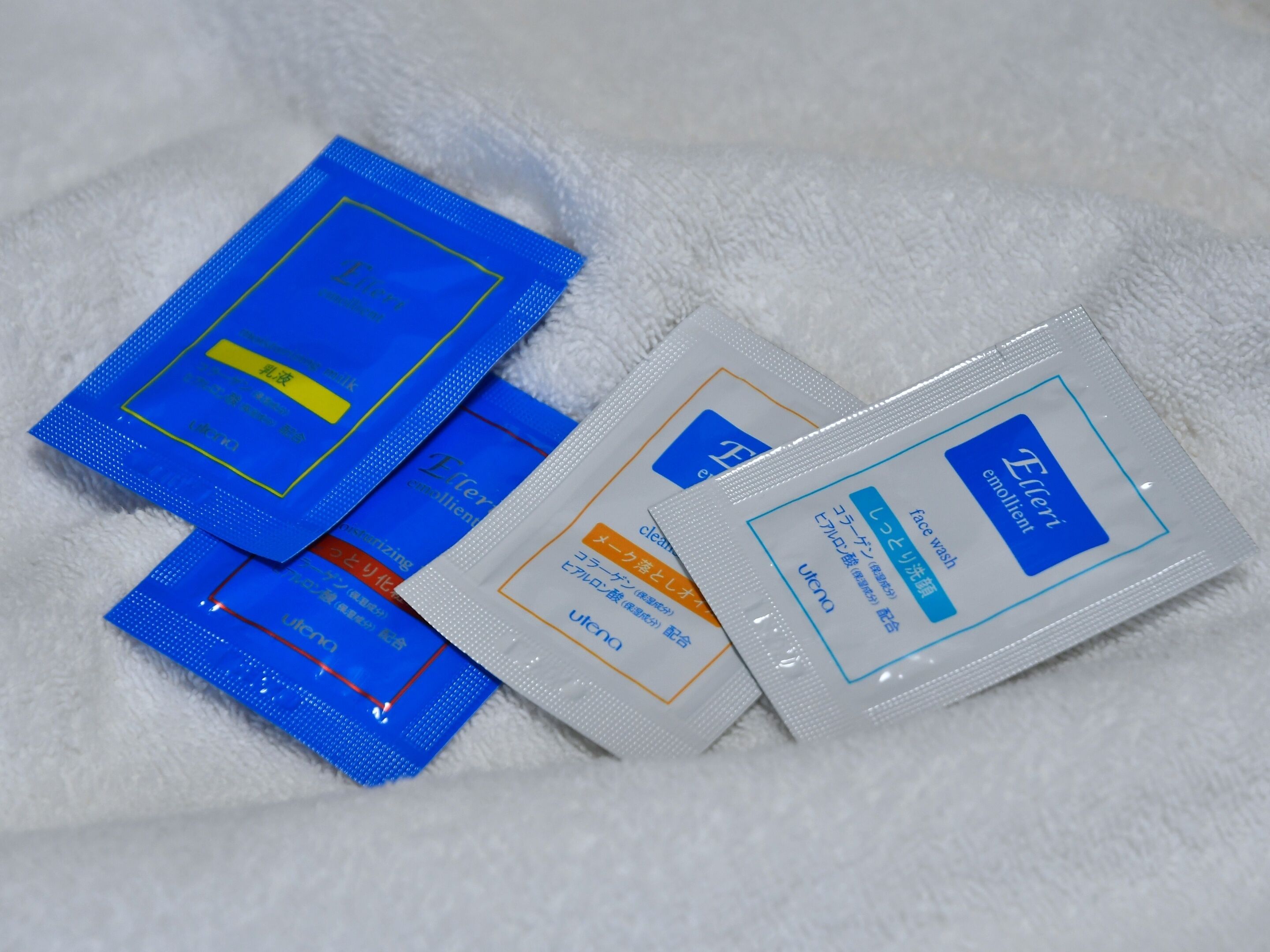 A collection of skincare products on a white towel.