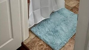A bathroom with a shower curtain, a blue textured mat, and a white door. - 1.5 blocks to beach. Close to cruise terminal. Safe neighborhood. Spacious 1/1 (Galveston)