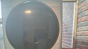 Two stacked front-loading washing machines in a room with brick walls and a window. - 1.5 blocks to beach. Close to cruise terminal. Safe neighborhood. Spacious 1/1 (Galveston)