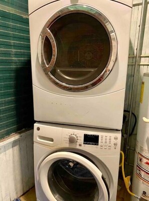 Eine übereinander gestellte Waschmaschine und ein Trockner in einem Waschraum.