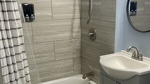 Une salle de bain moderne avec une baignoire, une douche et un lavabo.