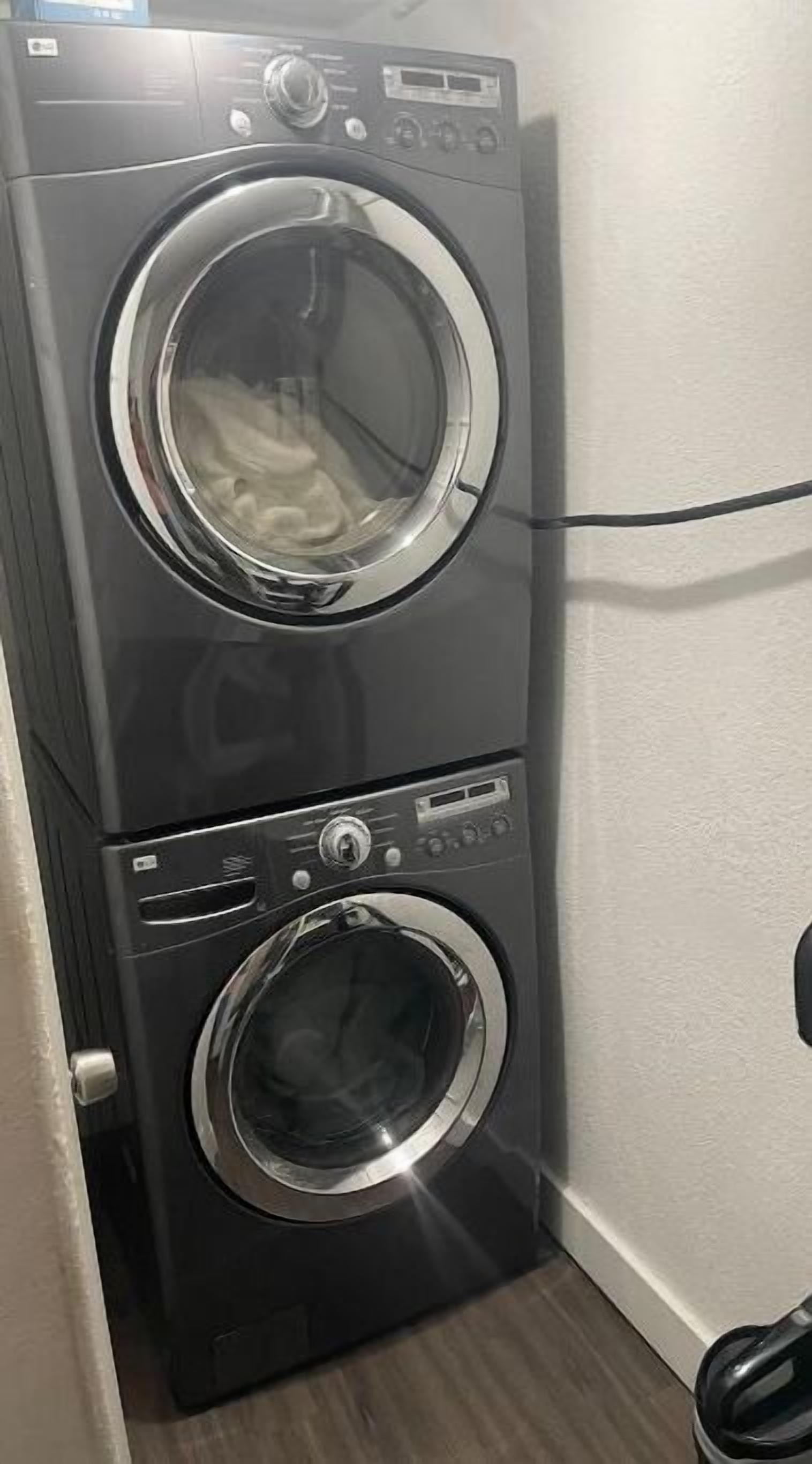 A stacked washer and dryer unit in a laundry room.