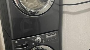 Une machine à laver et un sèche-linge superposés dans une buanderie.