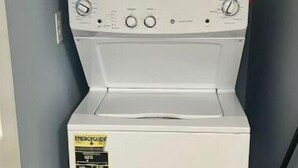 Een voorlader wasmachine met een bedieningspaneel en een sticker aan de voorzijde.