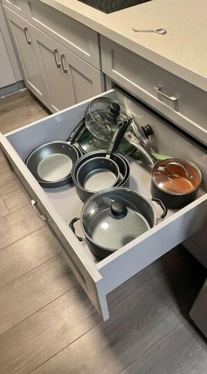 Un tiroir de cuisine contenant diverses casseroles et poêles.
