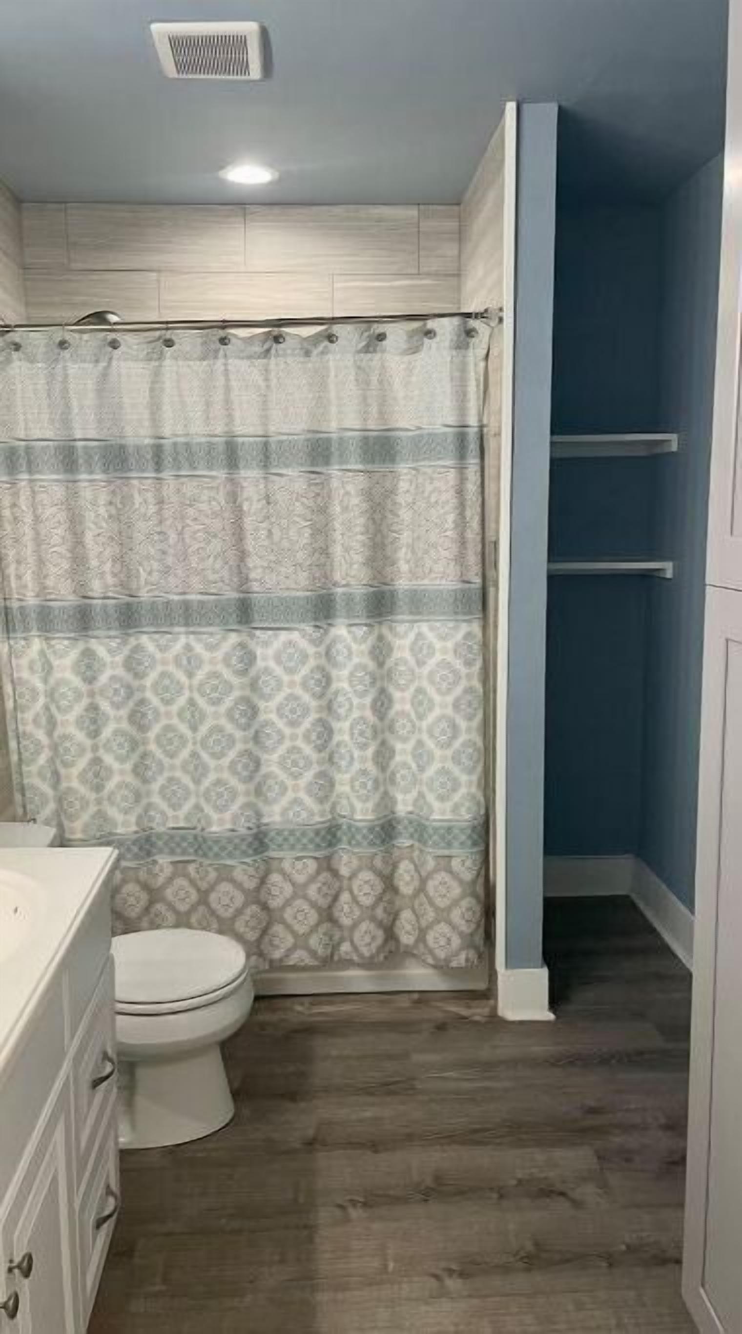 Une salle de bain avec des toilettes, un lavabo et un rideau de douche.