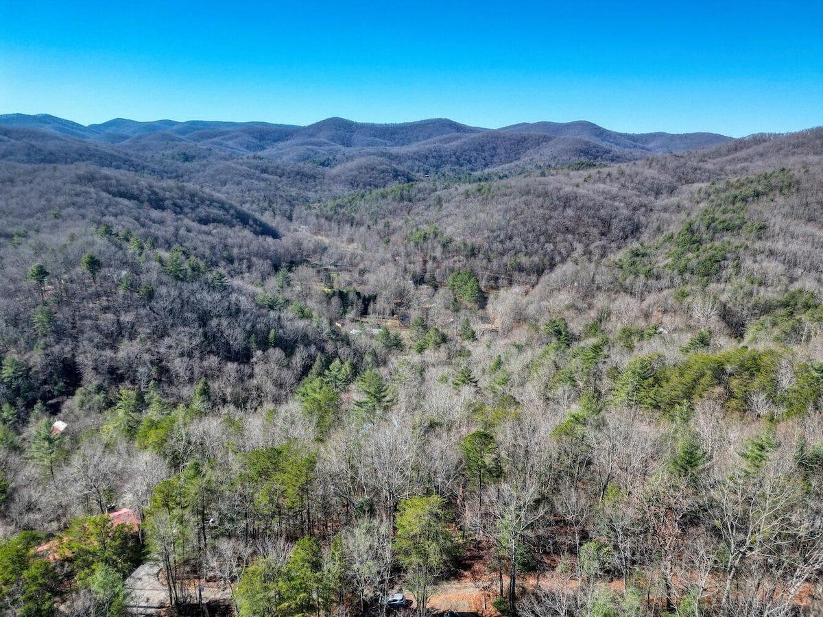 A mountainous landscape with dense forestation and a clear sky.