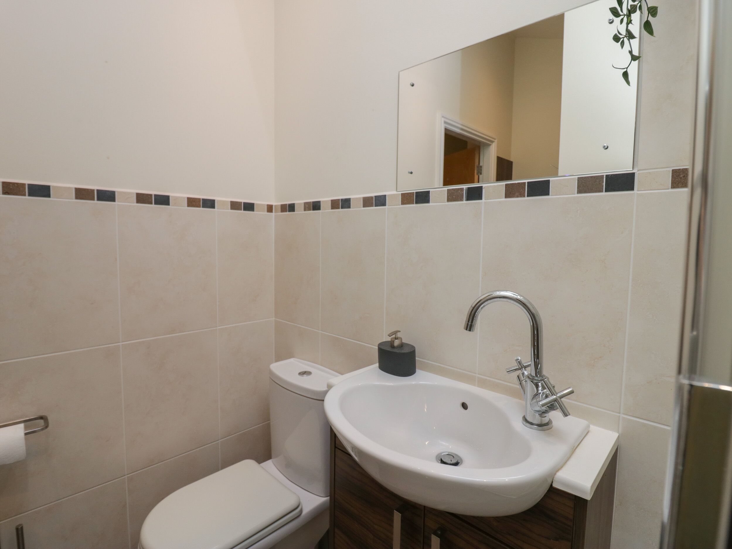 Un baño con inodoro, lavabo y espejo.