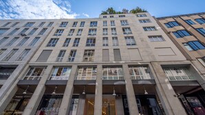 A multi-story building with large windows and a prominent entrance. - Duomo Collection (Milan)