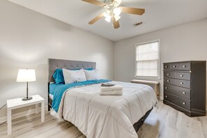 A bedroom with a bed, a dresser, a nightstand, a lamp, and a ceiling fan. - Cozy and Convenient
 (Cedartown)