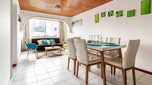 Et moderne spiseområde med træloft, hvide vægge og et stort vindue.