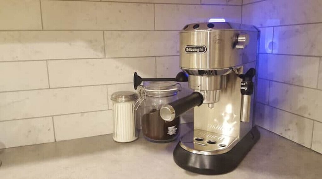 Eine Kaffeemaschine mit einer Kapseldose und einem Wasserbehälter auf einer Küchenarbeitsplatte.