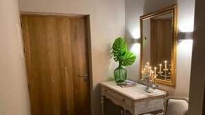 A wooden door, a small white vanity with a green plant, a candelabra, and a mirror with a gold frame. - Ccccccccccccccccccccccccccccccccccccccccccccccccccccccccccccccccccccccc (Medellín)