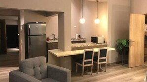A compact kitchen with a built-in refrigerator, a microwave, and a small island with chairs. - Ccccccccccccccccccccccccccccccccccccccccccccccccccccccccccccccccccccccc (Medellín)