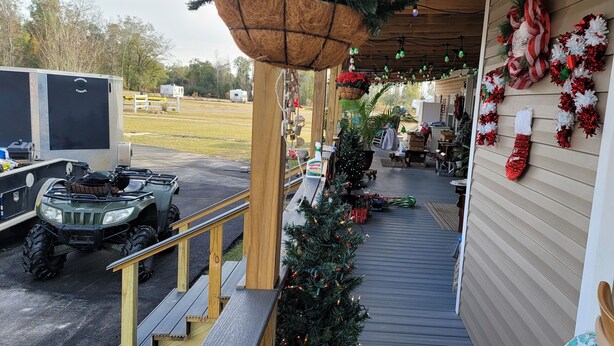 A covered porch with a Christmas tree, a dog, and a Jeep. - Farmhouse room 15minutes to, caverns state park
 Falling waters chipley Florida  (Cottondale)