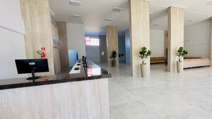 A spacious lobby with a reception desk, large pillars, and a bench area. - Spazzio diRoma - Cortezia ao Park diRoma (Caldas Novas)