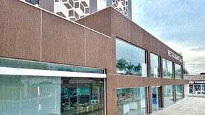 A modern building with a restaurant on the ground floor, featuring large glass windows and a clean, contemporary design. - Spazzio diRoma - Cortezia ao Park diRoma (Caldas Novas)
