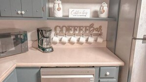 A kitchen with a coffee bar, a microwave, a coffee maker, and a dishwasher. - Cozy Cedartown Retreat
 (Cedartown)