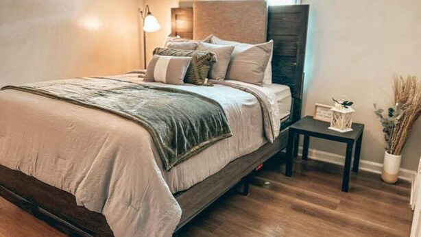 A bedroom with a bed, bedside tables, a lamp, and a window. - Cozy Cedartown Retreat
 (Cedartown)