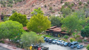 A parking lot with several cars and a pedestrian crossing sign. - Canyon Casitas at Zion (Springdale)
