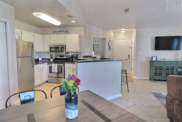 A modern kitchen with white cabinets, stainless steel appliances, and a central island.