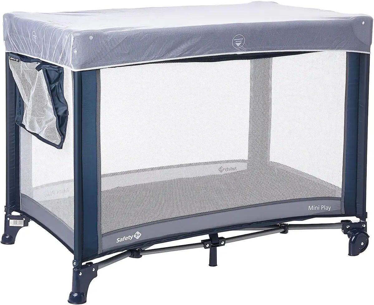 A portable playpen with a safety label, wheels, and a mesh screen.
