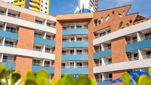 Un hotel de varios pisos con balcones, un diseño arquitectónico distintivo y cielo despejado.