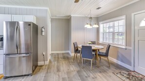 A kitchen with a stainless steel refrigerator, wooden ceiling fan, and a dining area with a table and chairs. - 2 Mi to Mashes Sands Beach: Quiet Home w/ Dock! (Panacea)
