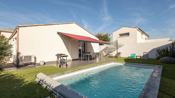 A swimming pool with a red canopy, a patio with outdoor furniture, and a well-maintained lawn. - Ô Soleil - Avec piscine privée (Vendres)