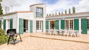 A patio with a grill and outdoor seating. - La Maison des Sources - A 20min du Puy du Fou (Mortagne-sur-Sèvre)