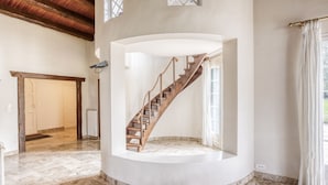 A spacious room with a marble floor, a wooden staircase, and a large window with curtains. - La Maison des Sources - A 20min du Puy du Fou (Mortagne-sur-Sèvre)