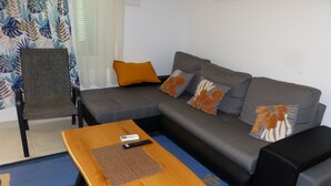 A living room with a grey sofa, a wooden coffee table, and a chair.
