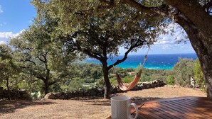 A hammock under a tree, a wooden table with a mug, and a view of the ocean. - Petite Pause de Fogata - Jolie vue mer (Corbara)