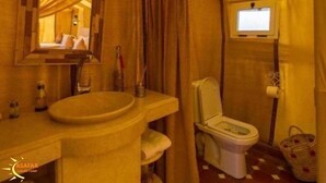 A compact bathroom with a sink, toilet, and mirror. - Asafar Luxury Camp (Rissani)