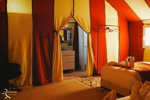 Quarto de acampamento de luxo com cama, espelho e guarda-roupa.