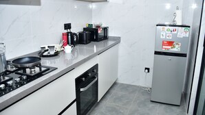Une cuisine moderne équipée d’une cuisinière à gaz, d’un four, d’un four à micro-ondes et d’un réfrigérateur.