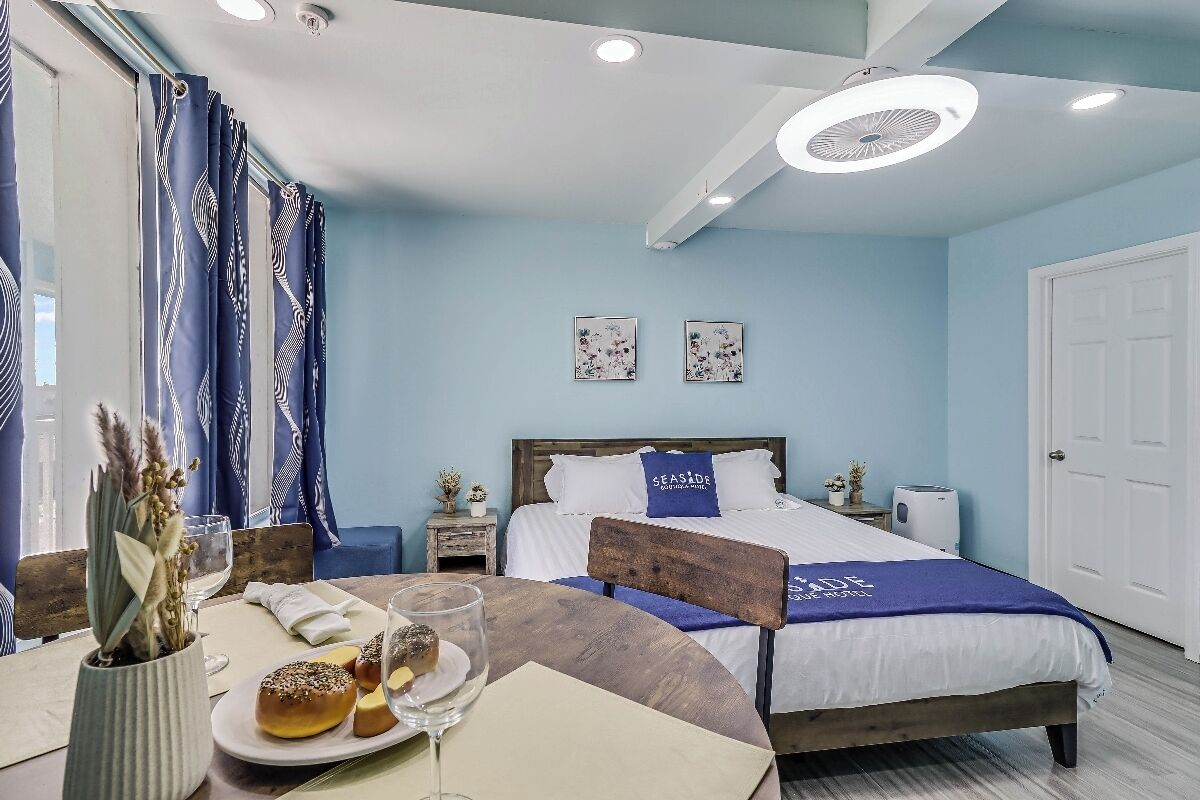 A bedroom with a bed, bedside tables, a bedside lamp, and a window with curtains.