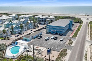 Un quartier résidentiel situé sur la côte, comprenant plusieurs maisons, une piscine et un parking.