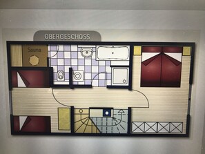 A floor plan of Obergeschoß with a sauna, a kitchen, and a dining area. - Ferienhaus Nordsee-koje mit Meerblick, Strandkorb, Kamin, Sauna (Wangerland)