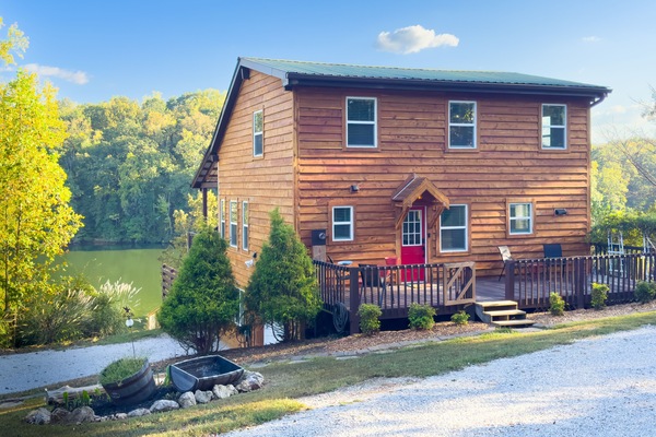 The front of the cabin features a small deck with a few chairs.