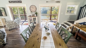 A dining area with a wooden table, chairs, and a clock on the wall.