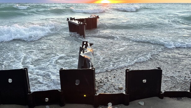 Une plage avec une structure en bois et des vagues.