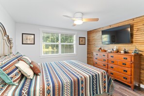 A bedroom with a bed, a dresser, a ceiling fan, a window, and a TV mounted on the wall. - NEW LISTING- Riverfront / Unique / Perfect location/ Private  (Lakeview)