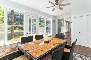 A dining area with a glass table, black wicker chairs, and a view of a lake. - NEW LISTING- Riverfront / Unique / Perfect location/ Private  (Lakeview)