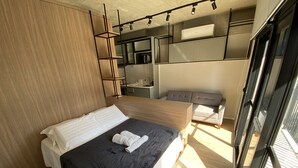 Una camera da letto moderna con un letto grande, un armadio a muro e un’area salotto.