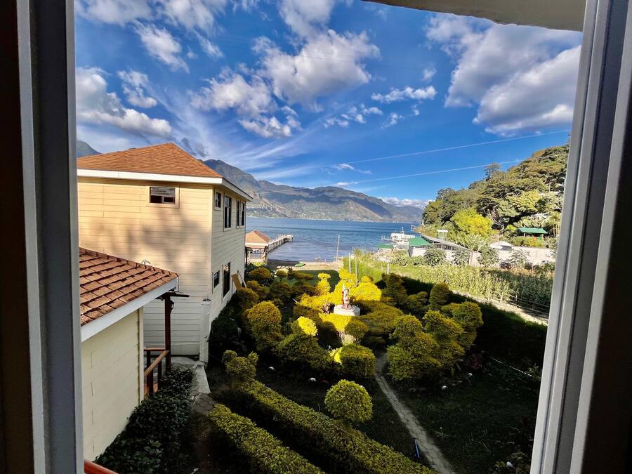 Vista de una casa con jardín y un lago.