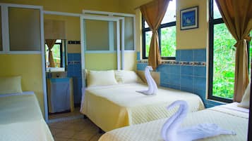Ein Hotelzimmer mit zwei Betten, einem Badezimmer und einem Fenster mit Vorhängen.