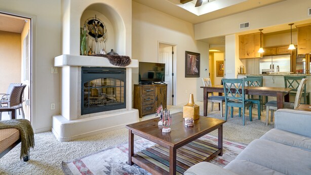 Un salón comedor amplio con chimenea, zona de estar y cocina.
