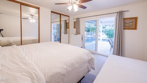 A bedroom with a large bed, a ceiling fan, a sliding glass door leading to a balcony, and a framed picture on the wall. - Casa De for 8people/3BD 3BA, 10people/3BD 4BA,+12people/4BD 4BA (Thousand Oaks)
